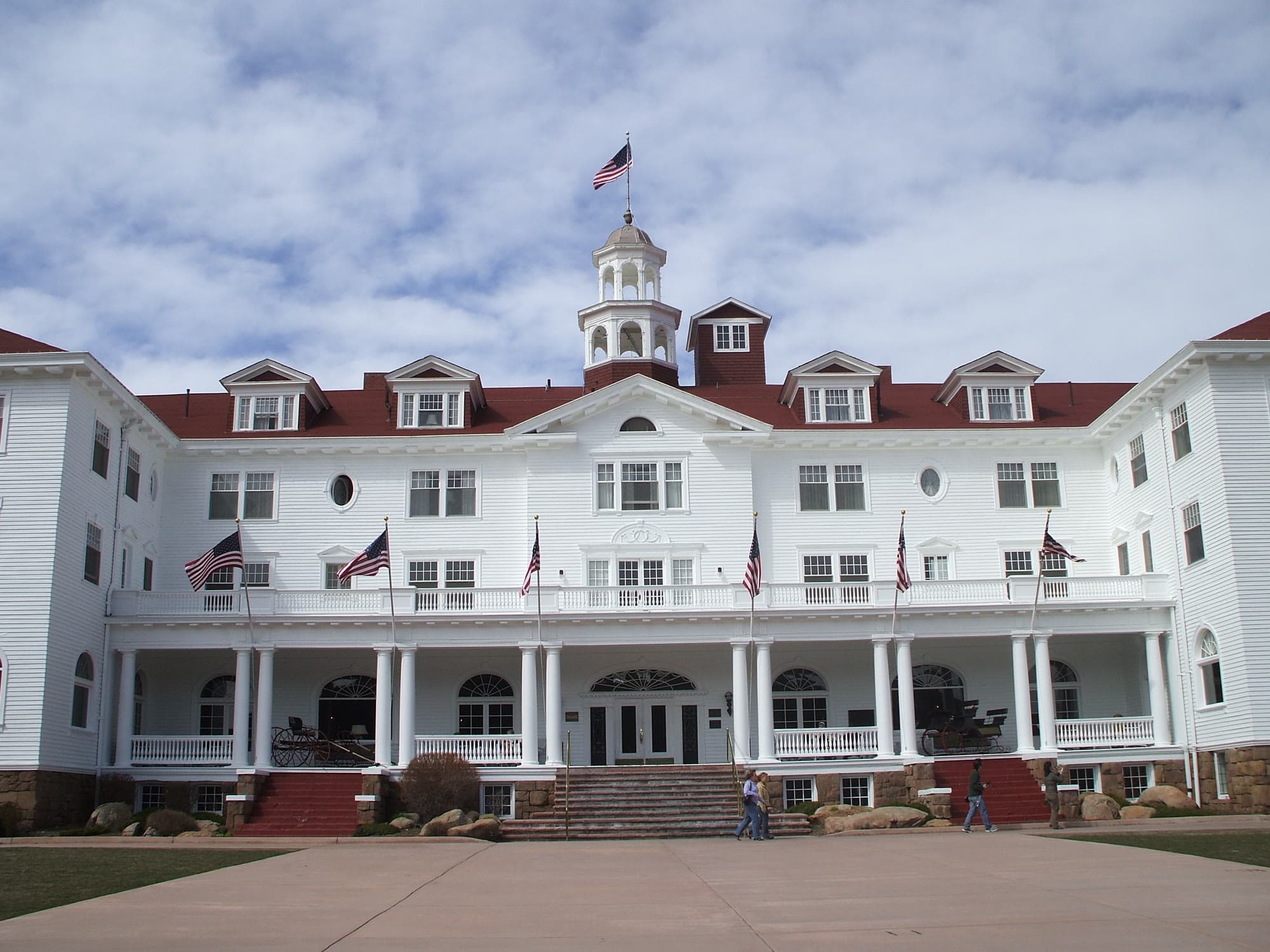 The Stanley Hotel, a white Victorian resort in Estes Park, with the Rocky Mountains behind it